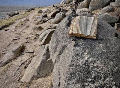 photograph “II.2024” par David Farreny — www.farreny.net — Andorre, Andorra, Encamp, Engolasters, lac, lake, barrage, dam, mur, wall, paroi, béton, concrete, rochers, rocks, boulders, chemin, path, livre, book, papier, paper, humide, wet, froissé, crumpled, pages