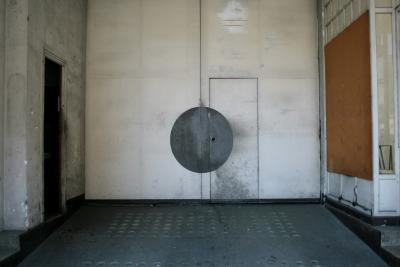 photograph “III.2012” par David Farreny — www.farreny.net — France, garage, porte, door, portail, gate, cercle, circle, gris, grey, gray, disque, disc, disk, bois, wood, ciment, cement, baie, vitrée, glass, window, verre, vitre, marches, steps, béton, concrete, plaque, contreplaqué, plywood, sheet, Occitanie, Rouergue, Aveyron, Espalion