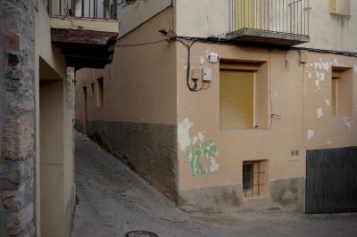 photograph “XI.2021 — Faces of home, 136” par David Farreny — www.farreny.net — Espagne, España, Espanya, Spain, Catalogne, Cataluña, Catalunya, Lérida, Lleida, Alt Urgell, Coll de Nargó, bourgade, town, village, rue, street, angle, coin, corner, bâtiment, building, vieux, old, ciment, cement, pierre, stone, logo, illustration, Limit KT, balcons, balconies, fenêtres, windows, câbles, cables, fils, wires, asphalte, asphalt, bitume, blacktop, garage, portail, domicile, home