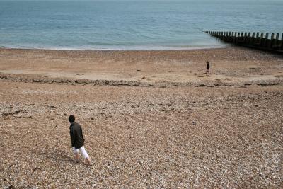 photograph “VII.2010 — Parallel careers” par David Farreny — www.farreny.net — Royaume-Uni, United Kingdom, Angleterre, England, GB, UK, Sussex, Eastbourne, paysage, landscape, seascape, Manche, Channel, mer, sea, côte, coast, plage, beach, horizon, gravier, gravel, épi, groyne, brise-lames, breakwater, galets, shingle, eau, water, bois, wood, jeunes filles, girls, promeneuses, walkers, Li*, Lu*