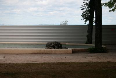 photograph “VI.2011” par David Farreny — www.farreny.net — France, jardin, garden, public, gardens, parc, park, bassin, pièce d'eau, ornemental, pond, rocaille, rockery, rochers, rocks, rockwork, arbres, trees, palissade, boarding, métal, metal, tôle, sheet, herbe, grass, vide, empty, emptiness, Occitanie, Rouergue, Aveyron, Rodez