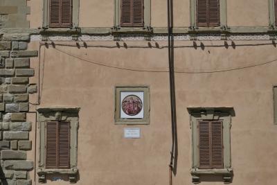 photograph “VIII.2022” par David Farreny — www.farreny.net — Italie, Italia, Italy, Toscane, Toscana, Tuscany, Arezzo, piazza del Duomo, mur, wall, pierre, stone, fenêtres, windows, volets, shutters, fil, wire, câbles, cables, gouttière, drainpipe, peinture, painting, Vierge Marie, Virgin Mary, Jésus, Jesus, Christ, plaque, plate, lampes, lamps