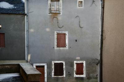 photograph “II.2015 — Faces of home, 271” par David Farreny — www.farreny.net — France, Occitanie, Rouergue, Aveyron, village, hiver, winter, maison, house, fermée, closed, vieille, old, façade, facade, ciment, cement, fenêtres, windows, porte, door, gouttières, drainpipes, toit, roof, ardoises, slates, froid, cold, neige, snow, métal, metal, volets, shutters, bois, wood, dépression, depression, domicile, home