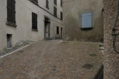 photograph “VI.2021” par David Farreny — www.farreny.net — France, Occitanie, Ariège, Ax-les-Thermes, ville, city, village, rue, street, vide, empty, emptiness, porte, door, fenêtres, windows, volets, shutters, bois, wood, pavé, cobblestone, métal, metal, pierre, goulotte, chute, plastique, plastic, câble, cable, fil, wire, crépi, roughcast, ciment, cement, stone, mort, dead, pauvre, poor