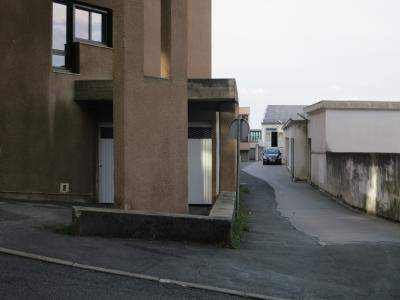 photograph “IX.2014 — Faces of home, 85” par David Farreny — www.farreny.net — France, domicile, home, immeuble, building, bâtiment, béton, concrete, garage, rue, street, voiture, car, bitume, asphalte, blacktop, asphalt, panneau routier, roadsign, fenêtre, window, trottoir, pavement, lumière, light, pilier, pillar, ville, city, Occitanie, Aveyron, Rouergue, Rodez