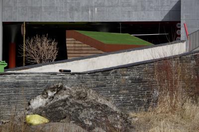 photograph “II.2023” par David Farreny — www.farreny.net — Andorre, Andorra, Canillo, bâtiment, building, neige, snow, tas, pile, heap, sale, dirty, mur, wall, pierre, stone, béton, concrete, rampe, ramp, arbuste, shrub, poubelle, conteneur, trash, container, bin, abri, shelter, bois, wood, toit, roof, vert, green, parking, car park, souterrain, underground, rambarde, guardrail, métal, metal, panneau, sign, roadsign, tuyau, pipe, plastique, plastic, rouge, red, sac, bag, jaune, yellow, profusion