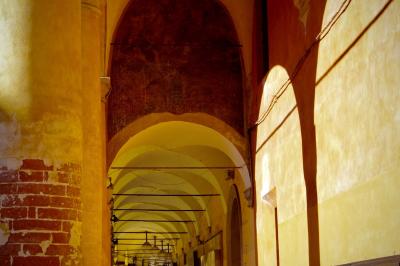 photograph “X.2019” par David Farreny — www.farreny.net — Italie, Italia, Italy, Émilie-Romagne, Emilia-Romagna, Bologne, Bologna, ville, city, rue, street, arcades, arcs, archs, arches, colonnes, columns, pillars, piliers, briques, bricks, lampes, lamps, câbles, cables, fils, wires, mur, wall, ombres, shadows, automne, autumn, fall, jaune, yellow, beige
