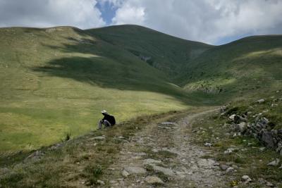 photograph “VII.2021” par David Farreny — www.farreny.net — Espagne, España, Spain, Catalogne, Cataluña, Catalunya, Catalonia, Barcelone, Barcelona, Berguedà, Castellar de n'Hug, Castellar de Nuch, montagnes, mountains, Pyrénées, Pyrenees, chemin, path, pierres, stones, été, summer, nuages, clouds, ombre, shadow, herbe, grass, femme, woman, randonneuse, hiker, chapeau, hat, paille, straw, backpack, sac à dos, É*