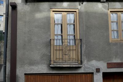 photograph “XI.2022 — Faces of home, 191” par David Farreny — www.farreny.net — Andorre, Andorra, Canillo, maison, house, façade, facade, fenêtres, windows, porte, door, balcon, balcony, rideaux, curtains, verre, vitre, glass, métal, metal, lampadaire, lamp, gouttière, drainpipe, volets, shutters, bois, wood, panneau, sign, Rectoria, plaque, plate, numéro, number, 36, ciment, cement, enduit, roughcast, domicile, home