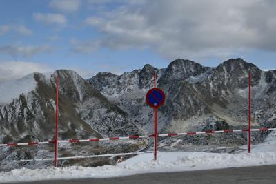 photograph “XI.2021” par David Farreny — www.farreny.net — Andorre, Andorra, Encamp, Le Pas de la Case, El Pas de la Casa, Envalira, col, port, Pyrénées, Pyrenees, montagnes, mountains, neige, snow, route, road, poteaux, posts, poles, métal, metal, panneau, routier, sign, roadsign, rouge, red, ciel, sky, nuages, clouds, station-service, gas station, Total, bitume, blacktop, asphalte, asphalt