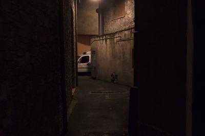 photograph “VII.2023 — At night” par David Farreny — www.farreny.net — Andorre, Andorra, Encamp, nuit, night, soir, evening, ville, city, bourgade, town, ruelle, alley, rue, street, immeubles, bâtiments, buildings, lumière, light, fenêtre, window, câbles, cables, fils, wires, volets, shutters, voiture, car, métal, metal, murs, walls, pierre, stone, gouttières, drainpipes, bitume, blacktop, asphalte, asphalt