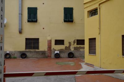 photograph “X.2019” par David Farreny — www.farreny.net — Italie, Italia, Italy, Toscana, Toscane, Tuscany, Pistoia, Pistoie, ville, city, garage, penus, tires, murs, walls, fenêtres, windows, brique, brick, gouttière, drainpipe, grilles, railings, persiennes, volets, shutters, bois, wood, barrière, gate, jaune, yellow, parabole