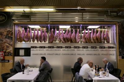 photograph “III.2023” par David Farreny — www.farreny.net — Espagne, España, Spain, Aragon, Aragón, Saragosse, Zaragoza, Caesaraugusta, charcuterie, deli, boucherie, butcher shop, restaurant, tables, clients, hommes, men, nappes, tablecloths, bouteilles, bottles, vin, wine, eau, water, chaises, chairs, assiettes, plates, extincteur, extinguisher, néon, neon, jambons, hams, suspendus, hanging, inscriptions, viande grillée, grilled meats, poulet grillé, grilled chicken, cuisson grillée, grilled cook, paellas, camera, vidéo, video, videocam, vitrine, window, verre, vitre, glass, midi, noon, profusion