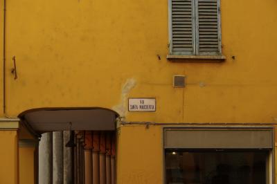 photograph “X.2019 — As you like it” par David Farreny — www.farreny.net — Italie, Italia, Italy, Émilie-Romagne, Emilia-Romagna, Bologne, Bologna, rue Sainte-Marguerite, via Santa Margarita, plaque, plate, mur, wall, yellow, jaune, câbles, cables, fils, wires, fenêtre, window, volets, shutters, bois, wood, vitrine, baie, bay, arcades, colonnes, columns, piliers, pillars, passage, lampe, lamp, graffiti, carte postale, postcard