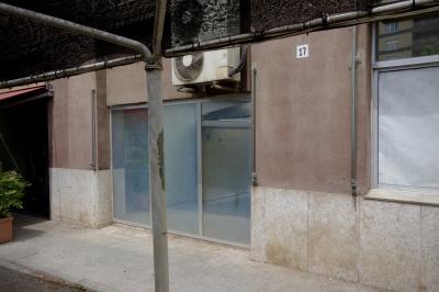 photograph “VI.2023 — Closedown” par David Farreny — www.farreny.net — Espagne, España, Espanya, Spain, Catalogne, Cataluña, Catalunya, Catalonia, Lérida, Lleida, Solsonès, Solsona, ville, city, rue, street, trottoir, pavement, fenêtre, window, baie, bay, vitrine, verre, vitre, glass, magasin, shop, store, reflet, reflection, mur, wall, béton, concrete, mât, poteau, pole, post, métal, metal, plaque, plate, numéro, number, 17, climatisation, unités extérieures, air conditioning, outdoor units, pot, jardinière, planter, plante, plant, bâche, sheet