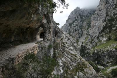 photograph “VII.2020” par David Farreny — www.farreny.net — Espagne, Spain, España, Asturies, Asturias, principauté, Poncebos, Cabrales, sentier du Cares, ruta del Cares, senda del Cares, Garganta divina, gorge, montagne, mountain, pics d'Europe, picos de Europa, peaks of Europe, nature, paysage, landscape, vallée, valley, nuages, clouds, rocher, rock, randonnée, trail, hike, hiking, randonneurs, hikers, chemin, path, précipice, gouffre, abyss, carte postale, postcard, trou, hole, tunnel, passage