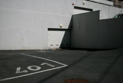photograph “III.2012” par David Farreny — www.farreny.net — France, ville, city, immeuble, bâtiment, building, garage, parking, car park, places, spaces, numéros, numbers, 401, 501, béton, concrete, voiture, car, lampes, lamps, portails, gates, murs, walls, bitume, blacktop, asphalte, asphalt, ombre, shadow, rambarde, guardrail, Occitanie, Aveyron, Rouergue, Rodez