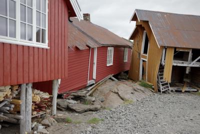 photograph “VII.2014 — Run away to the North, 88” par David Farreny — www.farreny.net — Norvège, Norway, Norge, Nord-Norge, Nordland, Lofoten, Flakstad, Nesland, maisons, houses, bois, wood, rouge, red, Falun, jaune, yellow, planches, planks, roche, rocher, rock, toits, roofs, tôle ondulée, corrugated iron, rouille, rust, rusty, porte, door, fenêtres, windows, escalier, staircase, marches, steps, délabré, décati, decayed, abandonné, abandoned, fils, wires, câbles, cables