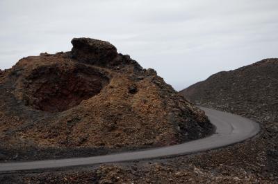 photograph “V.2016 — Lancerotte, 7” par David Farreny — www.farreny.net — Espagne, Spain, España, Canaries, Canary, Canarias, Lanzarote, Lancerotte, île, island, Tinajo, Timanfaya, parc national, national park, lave, lava, volcans, volcanoes, rocher, rock, route, road, trou, hole, cratère, crater, virage, bend, rugueux, rough