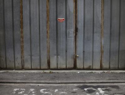 photograph “II.2017 — Passage” par David Farreny — www.farreny.net — France, Occitanie, Gascogne, Gers, Auch, garage, portail, gate, métal, metal, fermé, closed, cadenas, lock, numéro, number, 16 bis, panneau, sign, moitié, mid, ne pas stationner, do not park, trottoir, pavement, bitume, blacktop, asphalte, asphalt, mention, inscription, passage, peinture, paint