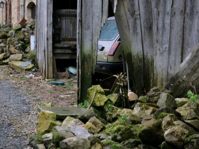 photograph “III.2014 — Damp” par David Farreny — www.farreny.net — France, voiture, car, Renault, 5, abri, shed, bois, wood, planches, planks, pierres, stones, tas, pile, heap, humidité, dampness, humide, damp, printemps, spring, mousse, moss, maison, house, brique, brick, ouverture, opening, trou, hole, pourri, rotten, lampadaire, lamp, volets, shutters, Aveyron, Occitanie, Rouergue, Rignac