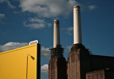 photograph “X.2010 — Battersea hunt, 7” par David Farreny — www.farreny.net — Royaume-Uni, United Kingdom, Angleterre, England, GB, UK, Londres, London, Battersea, Wandsworth, centrale électrique, power station, Battersea power station, cheminées, chimneys, brique, brick, usine, factory, industrie, industry, ville, city, paysage, landscape, cityscape, urbain, ombre, shadow, lampadaire, réverbère, street lamp, publicité, advertising, pub, ad, panneau, affichage, billboard, hoarding, océan, ocean, jaune, yellow, nuages, clouds, échafaudages, scaffolding, fenêtres, windows