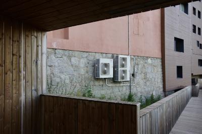 photograph “VII.2023” par David Farreny — www.farreny.net — Andorre, Andorra, Encamp, Le Pas de la Case, El Pas de la Casa, immeuble, bâtiment, building, mur, paroi, wall, bois, wood, pierre, stone, béton, concrete, fenêtres, windows, allée, pathway, planches, planks, climatiseurs, air conditioners, câbles, cables, fils, wires, graffiti