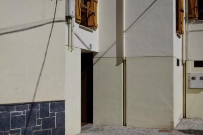 photograph “IX.2021 — Faces of home, 134” par David Farreny — www.farreny.net — Espagne, España, Spain, Catalogne, Cataluña, Catalonha, Lleida, Lérida, Aran, Vielha, Vielha e Mijaran, Viella, ville, city, rue, street, immeuble, bâtiment, building, béton, concrete, porte, door, fenêtres, windows, gouttières, drainpipes, métal, metal, volets, shutters, bois, wood, câbles, cables, fils, wires, ombre, shadow, pierre, stone, plaque, plate, numéro, number, 2, domicile, home