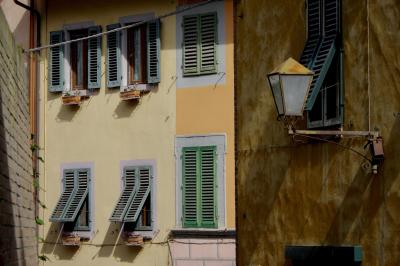 photograph “X.2019 — Faces of home, 127” par David Farreny — www.farreny.net — Italie, Italia, Italy, Toscane, Toscana, Tuscany, Pise, Pisa, San Miniato, Saint-Miniatus, ville, city, rue, street, fenêtres, windows, volets, shutters, bois, wood, lampe, lamp, murs, walls, parois, brique, brick, câbles, cables, fils, wires, métal, metal, gouttière, drainpipe, pots, fleurs, flowers, feuilles, leaves, automne, autumn, fall, domicile, home