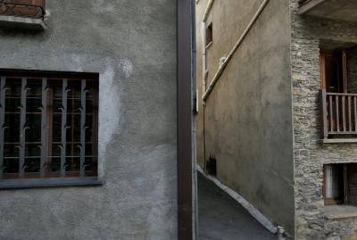 photograph “XI.2022 — Faces of home, 158” par David Farreny — www.farreny.net — Andorre, Andorra, Canillo, ville, city, bourgade, town, ruelle, alley, rue, street, bâtiment, building, maison, house, fenêtres, windows, grille, railings, coin, corner, angle, gouttière, drainpipe, pierre, stone, bois, wood, béton, concrete, ciment, cement, métal, metal, domicile, home