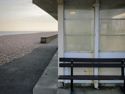 photograph “V.2013” par David Farreny — www.farreny.net — Royaume-Uni, United Kingdom, Grande-Bretagne, Great Britain, Angleterre, England, GB, UK, Sussex, West Sussex, Worthing, front de mer, seafront, plage, beach, galets, pebbles, shingle, mer, sea, Manche, Channel, horizon, eau, water, paysage, landscape, marin, seascape, soir, evening, muret, low wall, promenade, banc, bench, abri, shelter, métal, metal, bois, wood, fenêtres, windows, verre, glass, lumière, light