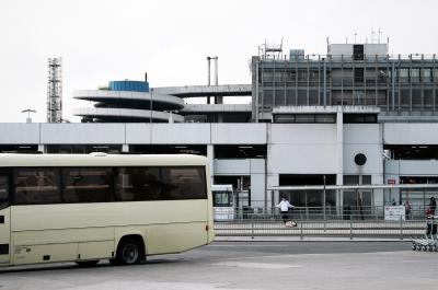photograph “IV.2009 — Interlude” par David Farreny — www.farreny.net — Irlande, Ireland, Éire, Leinster, Dublin, aéroport, airport, aérogare, air terminal, parking, car park, bus, car, coach, bâtiments, buildings, béton, concrete, chariots, trolleys, barrières, guardrails, voyageurs, travellers, spirale, spiral, métal, metal, trottoir, pavement, profusion