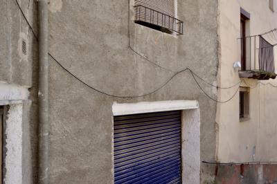 photograph “VI.2023 — Whatever” par David Farreny — www.farreny.net — Espagne, Spain, España, Espanya, Catalogne, Catalonia, Cataluña, Catalunya, Lérida, Lleida, Alt Urgell, Ribera d'Urgellet, El Pla de Sant Tirs, village, rue, street, béton, concrete, fenêtres, windows, gouttière, drainpipe, métal, metal, portail, gate, ciment, cement, balcon, balcony, fils, wires, câbles, cables, rampe, bannister, étendoir, clothes rack, rugueux, rough