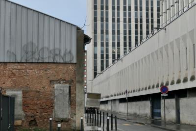 photograph “III.2024 — Whatever” par David Farreny — www.farreny.net — France, Occitanie, Haute-Garonne, Toulouse, rue, street, bâtiment, immeuble, building, béton, concrete, fenêtres, windows, panneaux, signs, routiers, roadsigns, poteaux, posts, poles, lampes, lamps, mur, wall, brique, brick, vieux, old, paroi, métal, metal, tôle ondulée, corrugated iron, tag, graffiti, camion, truck, lorry, parpaings, breeze-blocks, gouttière, drainpipe, portail, gate, rambarde, guardrail