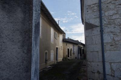 photograph “I.2025 — Bottom of the year” par David Farreny — www.farreny.net — France, Occitanie, Gascogne, Gascony, Lomagne, Saint-Clar, village, hiver, winter, rue, street, ruelle, alley, sombre, dark, pénombre, darkness, maisons, houses, pierre, stone, fenêtres, windows, volets, shutters, bois, wood, portes, doors, câbles, cables, fils, wires, enduit, roughcast, crépi, gouttière, drainpipe, gutter, antenne, antenna, nuages, clouds, triangle, dépression, depression
