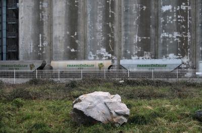 photograph “I.2010 — Northwest passage, 19. Stores” par David Farreny — www.farreny.net — France, Nantes, Loire-Atlantique, Pays de la Loire, silos, entrepôts, warehouses, magasins, hiver, winter, vent, froid, cold, wind, grillage, fence, fencing, métal, metal, roc, rocher, rock, béton, concrete, industrie, industry, train, wagons, céréales, cereal, escaliers, stairs, clôture, inscription, sign, Transcéréales