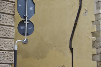 photograph “X.2019” par David Farreny — www.farreny.net — Italie, Italia, Italy, Toscana, Toscane, Tuscany, Pistoia, Pistoie, ville, city, immeuble, bâtiment, building, mur, paroi, wall, jaune, yellow, beige, coins, corners, angles, tuyau, pipe, métal, metal, panneaux, signs, routiers, roadsigns, pierre, stone, tag, graffiti, vide, empty, emptiness