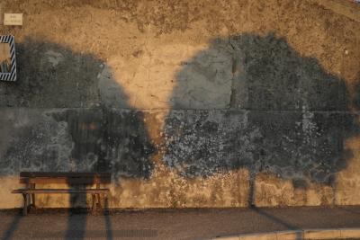 photograph “VIII.2019” par David Farreny — www.farreny.net — France, Occitanie, Gascogne, Gers, Jegun, été, summer, soir, evening, village, rue, street, mur, wall, paroi, ciment, cement, trottoir, pavement, banc, bench, bois, wood, arbres, trees, ombre, shadow, miroir, mirror, plaque, sign, soleil, sun, hachures, hatching