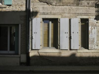 photograph “III.2025 — Faces of home, 273” par David Farreny — www.farreny.net — France, Occitanie, Tarn-et-Garonne, Septfonds, village, rue, street, maison, house, wall, mur, pierre, stone, cement, ciment, fenêtres, windows, volets, shutters, verre, vitre, glass, rideaux, curtains, brique, brick, gouttières, drainpipes, métal, metal, ombre, shadow, trottoir, pavement, balcon, balcony, domicile, home