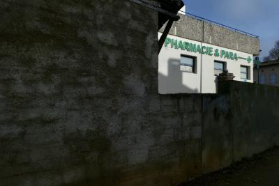 photograph “I.2024 — Whatever” par David Farreny — www.farreny.net — France, Occitanie, Tarn-et-Garonne, Caussade, bâtiment, immeuble, pharmacie, drugstore, enseigne, sign, Pharmacie & Para, béton, concrete, mur, wall, gouttière, cutter, ombre, shadow, cheminée, chimney, fenêtres, windows, arbre, tree