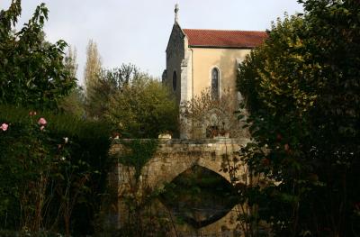 photograph “XI.2006 — In the morning” par David Farreny — www.farreny.net — France, Occitanie, Gascogne, Gascony, Gers, Fourcès, église, church, Saint-Laurent, Moyen Âge, Middle Ages, pont, bridge, XVe siècle, 15th century, pierre, stone, arbres, trees, fleurs, flowers, roses, matin, morning, croix, cross, toit, roof, tuiles, tiles, rivière, Auzoue, eau, water, reflet, reflection, feuilles, leaves, feuillage, foliage