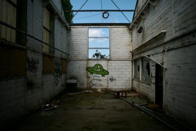 photograph “IV.2011” par David Farreny — www.farreny.net — France, usine, factory, industrie, industry, abandon, abandoned, murs, walls, tags, graffiti, métal, metal, fenêtres, windows, tuyaux, pipes, soucoupe volante, flying saucer, saut, jump, OVNI, UFO, signature, nuage, cloud, Occitanie, Aveyron, Rouergue, Decazeville