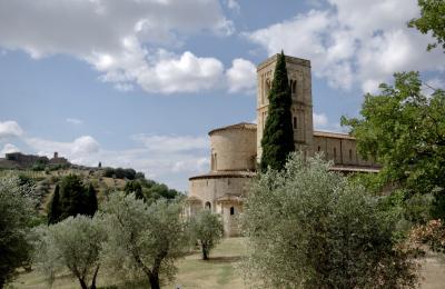 photograph “VIII.2022” par David Farreny — www.farreny.net — Italie, Italia, Italy, Toscane, Toscana, Tuscany, Montalcino, Castelnuovo dell'Abate, Sant'Antimo, abbaye, abbey, abbazia, église, church, IXe siècle, 9th century, arbres, trees, cyprès, cypress, oliviers, olive trees, roman, romanesque, campanile, bell tower, colline, hill, pierre, stone, carte postale, postcard
