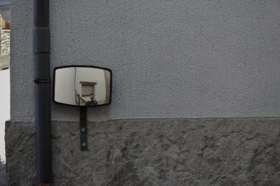 photograph “IV.2023” par David Farreny — www.farreny.net — Andorre, Andorra, Canillo, mur, wall, ciment, cement, enduit, roughcast, miroir, mirror, fenêtre, window, homme, man, photographe, photographer, autoportrait, selfportrait, gouttière, drainpipe, métal, metal, rue, street, pierre, stone