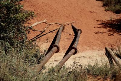 photograph “VIII.2011” par David Farreny — www.farreny.net — France, tuyaux, pipes, conduites, métal, metal, rouille, rust, rusty, coudes, bends, écrous, nuts, branche, branch, arbre, tree, bois, wood, herbe, grass, terre, earth, sol, soil, sable, sand, végétation, vegetation, Vaucluse, Rustrel, Colorado provençal, Provence-Alpes-Côte d'Azur