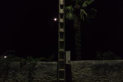 photograph “VIII.2015 — At night” par David Farreny — www.farreny.net — France, Occitanie, Gascogne, Gascony, Gers, Jegun, nuit, night, soir, evening, village, pure, low wall, pierre, stone, poteau, post, pole, électrique, electricity, lampadaire, lamp, lumière, light, palmier, palm, arbre, tree, haie, hedge, lune, moon, pénombre, darkness, sombre, dark