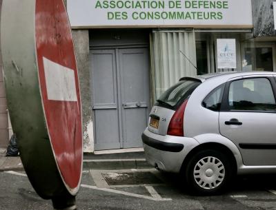 photograph “I.2012” par David Farreny — www.farreny.net — France, Occitanie, Rouergue, Aveyron, Rodez, ville, city, rue, street, voiture, car, bitume, blacktop, asphalte, asphalt, panneau, sign, routier, roadsign, sens interdit, one way, porte, door, enseigne, Association de défense des consommateurs, métal, metal, trottoir, pavement