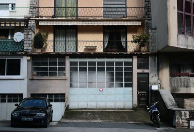 photograph “II.2010 — Faces of home, 7” par David Farreny — www.farreny.net — France, immeuble, building, façade, front, garage, porte, door, fenêtres, windows, balcons, balconies, parabole, satellite, dish, voiture, car, BMW, moto, motorbike, bike, intérieurs, interiors, chaises, chairs, étendoir, clotheshorse, rideaux, curtains, plantes, plants, 31, laid, ugly, béton, concrete, ciment, cement, Occitanie, Rouergue, Aveyron, Rodez