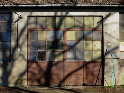 photograph “XII.2011” par David Farreny — www.farreny.net — France, Midi-Pyrénées, Aveyron, Rieupeyroux, Le Théron, garage, façade, facade, ciment, cement, métal, metal, hiver, winter, ombre, shadow, arbres, trees, verre, glass, carreaux, panes, fenêtres, windows, gouttière, gutter, toit, roof, tuiles, tiles, fil, électrique, electrical, wire, câble, cable, rouille, rust, rusty