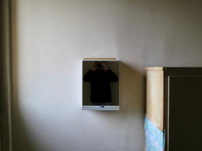 photograph “XII.2012 — Trapped” par David Farreny — www.farreny.net — France, autoportrait, selfportrait, miroir, mirror, glace, placard, cupboard, armoire, pharmacie, medicine, chest, cabinet, étiquette, label, bois, wood, mur, wall, crépi, roughcast, Occitanie, Rouergue, Aveyron, Rodez